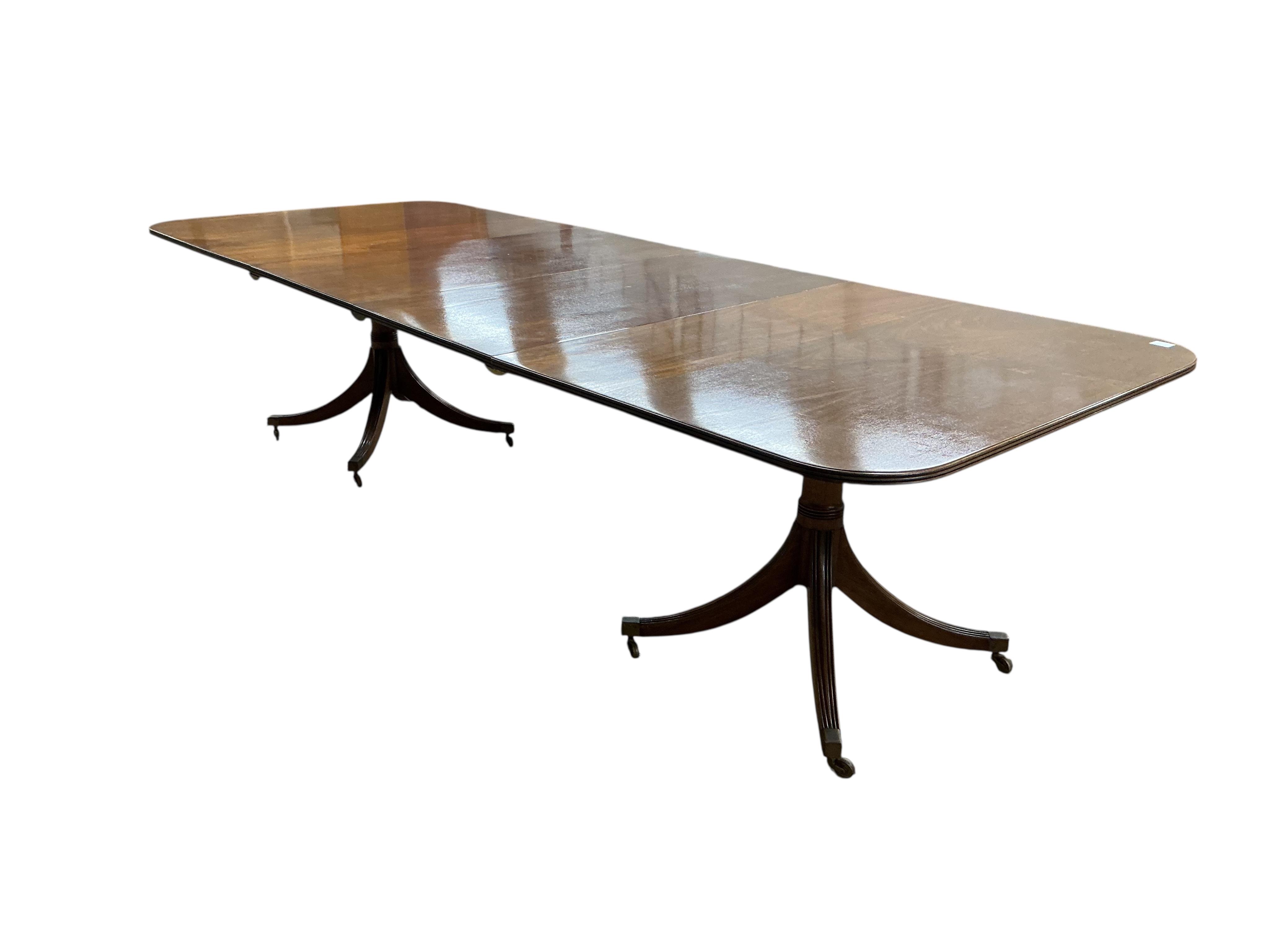 A Regency style mahogany twin pillar extending dining table, width 295cm extended, two spare leaves, depth 114cm, height 74cm